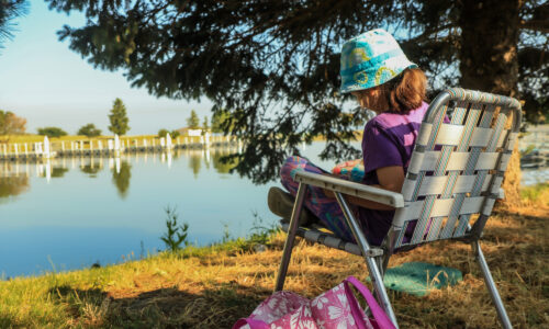 Girl sitting by lake