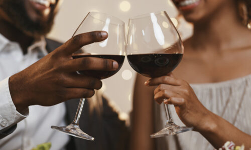 Couple clinking glasses with wine in them
