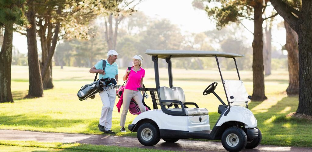 Two people with a golf cart